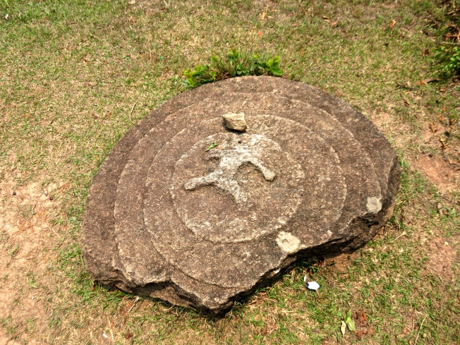 A lid stone or marker with a carving in the center of concentric circles