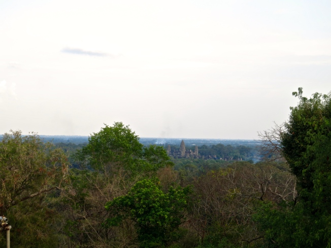 View of Angkor Wat through the trees from Phnom Bakheng
