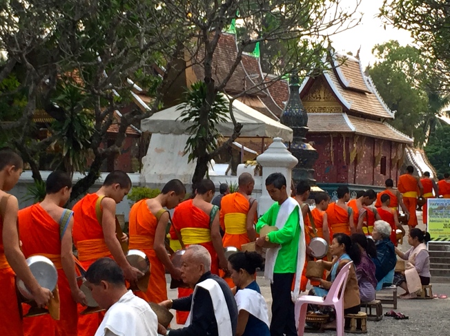 Tak Bat, alms-giving ceremony comes to an end and the monks file back into the temple.